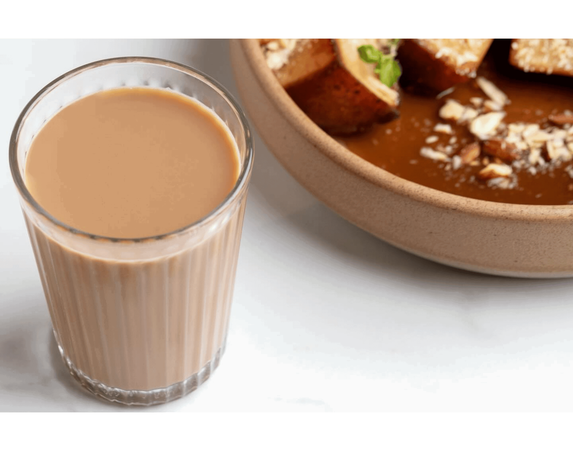 Creamy Indian chai tea latte served in a glass, perfect for warm beverages and authentic flavor. Pair it with traditional Indian dishes for an authentic experience.