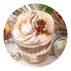 Delicious Indian chai latte with spices, whipped cream, and star anise, served in a glass jar, showcasing the rich flavors and aromatic spices offered by The Indian Pantry.