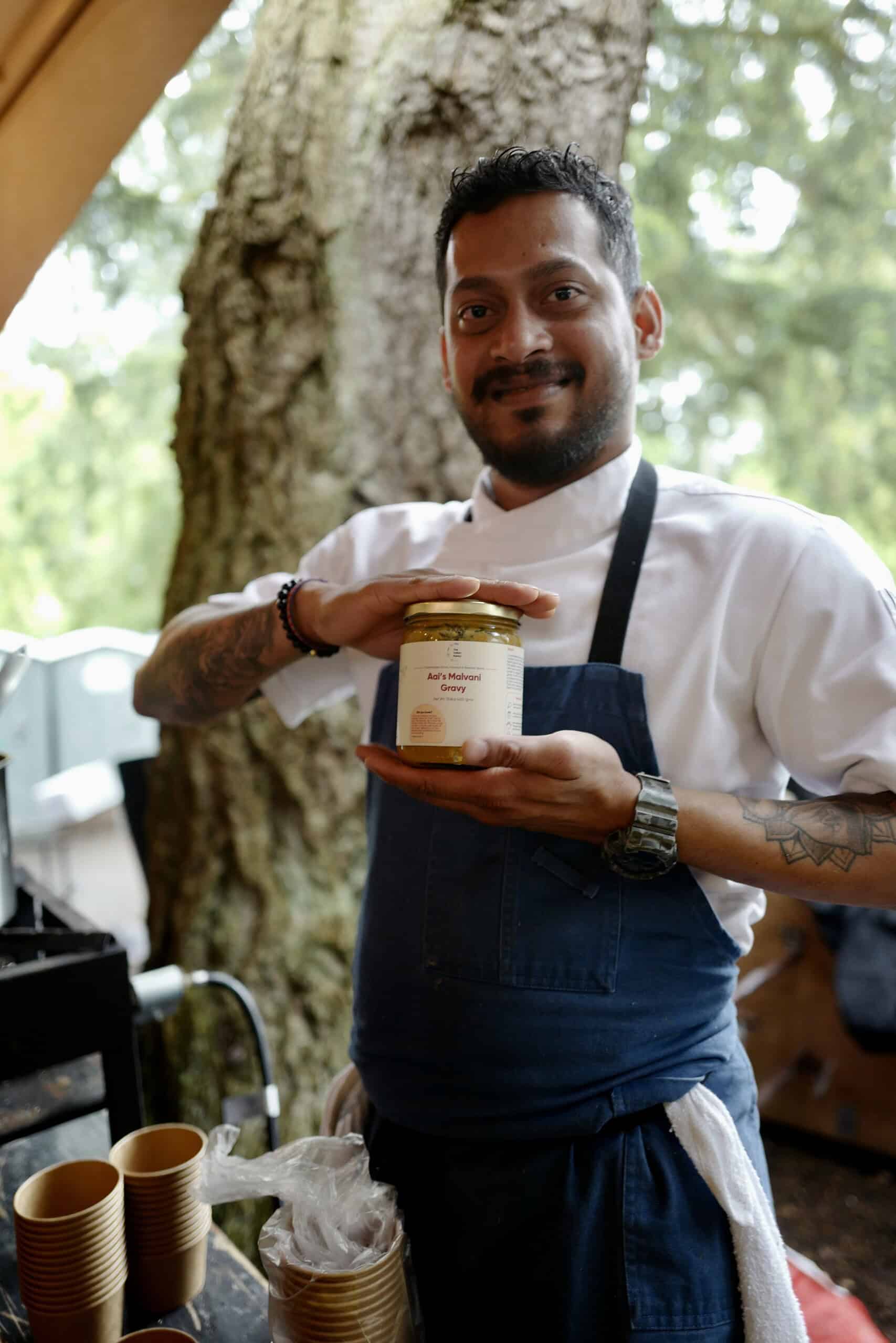 Expert chef holding jar of Aaji Malvani Gravy, emphasizing authentic Indian sauces and gravies, perfect for Indian cuisine enthusiasts and home cooks seeking genuine flavors.